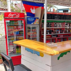 una tienda con dos máquinas de refrescos y una mesa en Villa Tropica en Kampot
