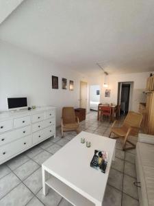 ein Wohnzimmer mit einem weißen Sofa und einem Tisch in der Unterkunft Résidence Palmyra - 2 Pièces pour 4 Personnes 764 in Le Barcarès