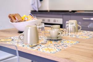 un comptoir de cuisine avec des tasses et des assiettes sur une table dans l'établissement Appartamento AL 45 B.go Roma -Vr- con garage, à Vérone