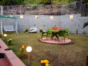 een tafel en stoelen in een tuin met verlichting bij DreamCatcher Boutique Hotels in Bhīm Tāl