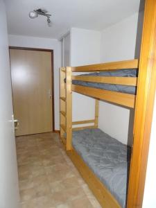 Pokój z 2 łóżkami piętrowymi i drzwiami w obiekcie Ambiance montagne front de neige w mieście Thollon-les-Mémises