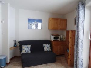 un salon avec un canapé noir et un micro-ondes dans l'établissement Ambiance montagne front de neige, à Thollon-les-Mémises 8 autres photos