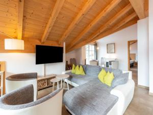 a living room with a couch and a tv at Luxury penthouse with Balcony Ski Storage Carport Lift in Brixen im Thale