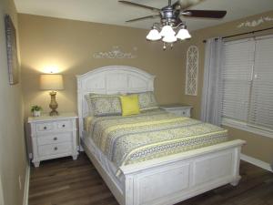 a bedroom with a white bed and a ceiling fan at Lakefront Condo A-3 in Hollister