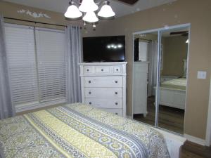 a bedroom with a bed and a dresser with a television at Lakefront Condo A-3 in Hollister