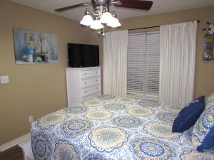 a bedroom with a bed and a dresser and a television at Lakefront Condo A-3 in Hollister