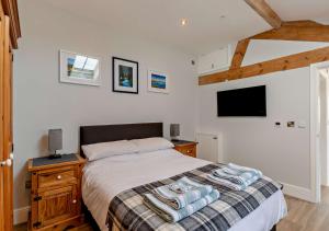 a bedroom with a bed and a tv on the wall at The Stables-Cilcain in Cilcain