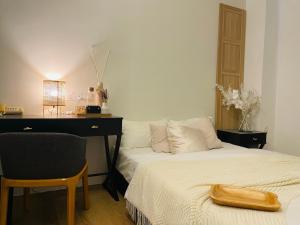 a bedroom with a bed and a desk and a chair at The Philea Suite in Kuala Lumpur
