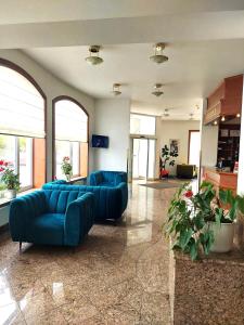 a large living room with blue couches and windows at Hotel Avion in Prague