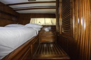 ein Schlafzimmer mit einem Bett auf einem Holzboot in der Unterkunft Tersane IV Vincitore 4 Hotel di Bruno Barbieri in Palermo