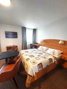 a hotel room with a bed and a table and chairs at Hotel Avion in Prague