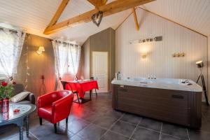 een badkamer met een bad en een tafel en stoelen bij CHALET DU REV'EAUBOIS in Larche