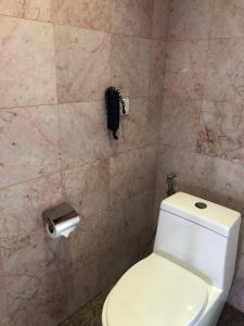 a bathroom with a toilet and a phone on the wall at Phnom Penh Era Hotel in Phnom Penh