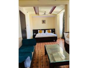 ジャイプールにあるHotel Maziz Prime, Jaipurのリビングルーム(ベッド1台、ソファ付)