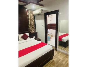 a hotel room with a bed and a mirror at Hotel Maziz Prime, Jaipur in Jaipur