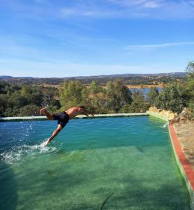 Un uomo si sta tuffando in una grande piscina d'acqua di Art residency Lagoon a Siviglia