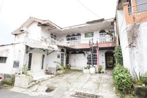 an old white house with a courtyard at OYO 93847 Blio Guest House Syariah in Bandung