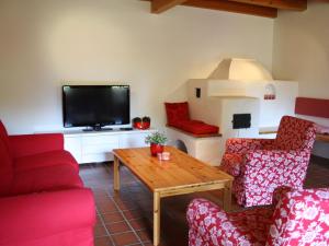 a living room with red furniture and a tv at Quaint Mansion near ski bus in Goldegg in Goldegg