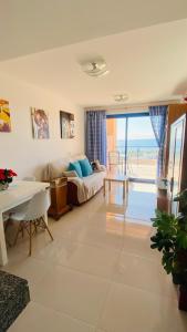 een woonkamer met een bed en uitzicht op de oceaan bij SUNRISE ATALAYA Amanecer suite in Mojácar