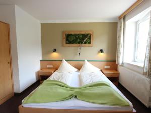 a bedroom with a bed with a green blanket on it at Modern Apartment in Fieberbrunn with Terrace in Fieberbrunn