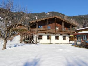 a large wooden house with snow in front of it at Quaint Mansion near ski bus in Goldegg in Goldegg