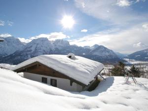 IselsbergにあるChalet in Iselsberg Stronach near ski liftの山々を背景に雪に覆われた家