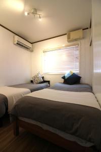 2 camas en una habitación con ventana en Whale Okinawa, en Kadena