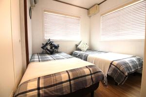 Duas camas num pequeno quarto com janelas em Whale Okinawa em Kadena