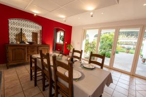 een eetkamer met rode muren en een tafel en stoelen bij Villa Le Blavet in Puget-sur Argens
