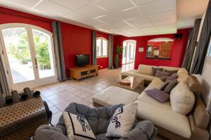 een woonkamer met een bank en een tv bij Villa Le Blavet in Puget-sur Argens