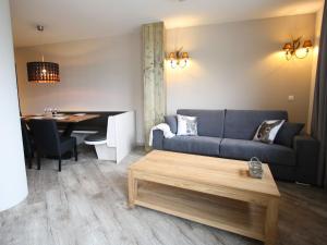 ein Wohnzimmer mit einem Sofa und einem Tisch in der Unterkunft Vogue Apartment in Sankt Margarethen im Lungau near Ski Lift in Sankt Margarethen im Lungau