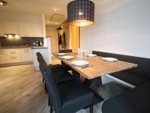 a dining room with a wooden table and black chairs at Vogue Apartment in Sankt Margarethen im Lungau near Ski Lift in Sankt Margarethen im Lungau