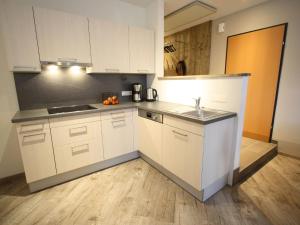 a kitchen with white cabinets and a sink at Vogue Apartment in Sankt Margarethen im Lungau near Ski Lift in Sankt Margarethen im Lungau