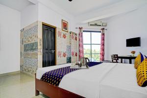 1 dormitorio con 1 cama grande y escritorio en SPOT ON Cherai Homes, en Cherai Beach
