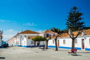 una calle en una ciudad con edificios blancos en Casa Sol e Areia Villa Eira Nova en Porto Covo