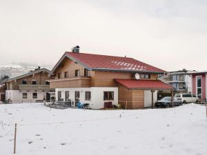 dom z czerwonym dachem w śniegu w obiekcie Holiday home in ski area in Mittersill w mieście Mittersill