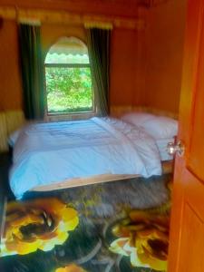 a bedroom with a large bed and a window at H'mông cổ trấn sapa homestay in Sa Pa