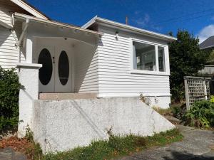 ein weißes Haus mit einer Tür und einem Fenster in der Unterkunft Wellington double bedroom in Wellington