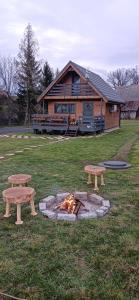 two picnic tables and a fire in front of a building at Domek Skitnica in Mirsk