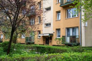 un immeuble d'appartements avec un arbre en face de celui-ci dans l'établissement Podgórze Apartment - near Vistula river, City View - by Rentujemy, à Cracovie