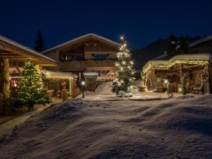 キルヒドルフ・イン・チロルにあるBoutique Apartment in Kirchdorf with Swimming Poolの雪中のクリスマスの木々が植えられたスキー場