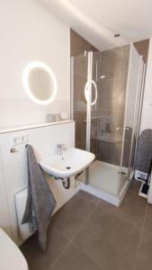 W łazience znajduje się umywalka i prysznic. w obiekcie Kahnschifferhaus Mönkebude w mieście Mönkebude