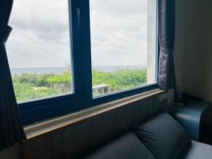 a room with two windows and a couch with a view at 綠島209角落Corner of Green Island 台東縣民宿編號第2003號 in Green Island