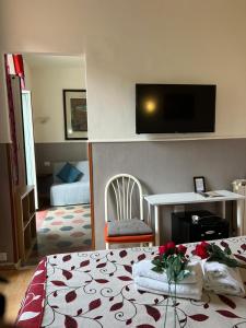 ローマにあるAffitacamere Radiのベッド1台、壁掛けテレビが備わるホテルルームです。