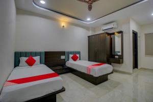 um quarto de hotel com duas camas e um espelho em BHILVA INN em Warangal