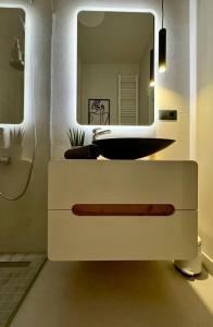 a bathroom with a sink and a mirror at Urban Sunset Apartment in Sibiu