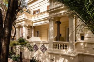 a large white house with a balcony at Hotel Medium Romantic in Sitges