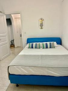a blue bed with a blue headboard in a bedroom at White Dream Apartment in Skopelos Town