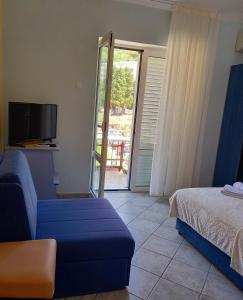 a room with a bed and a couch and a tv at Apartments Mitrovići Miločer in Sveti Stefan