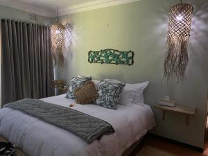 een slaapkamer met een bed met kussens erop bij Luxury Upmarket Guesthouse 20 on 4th in Rustenburg